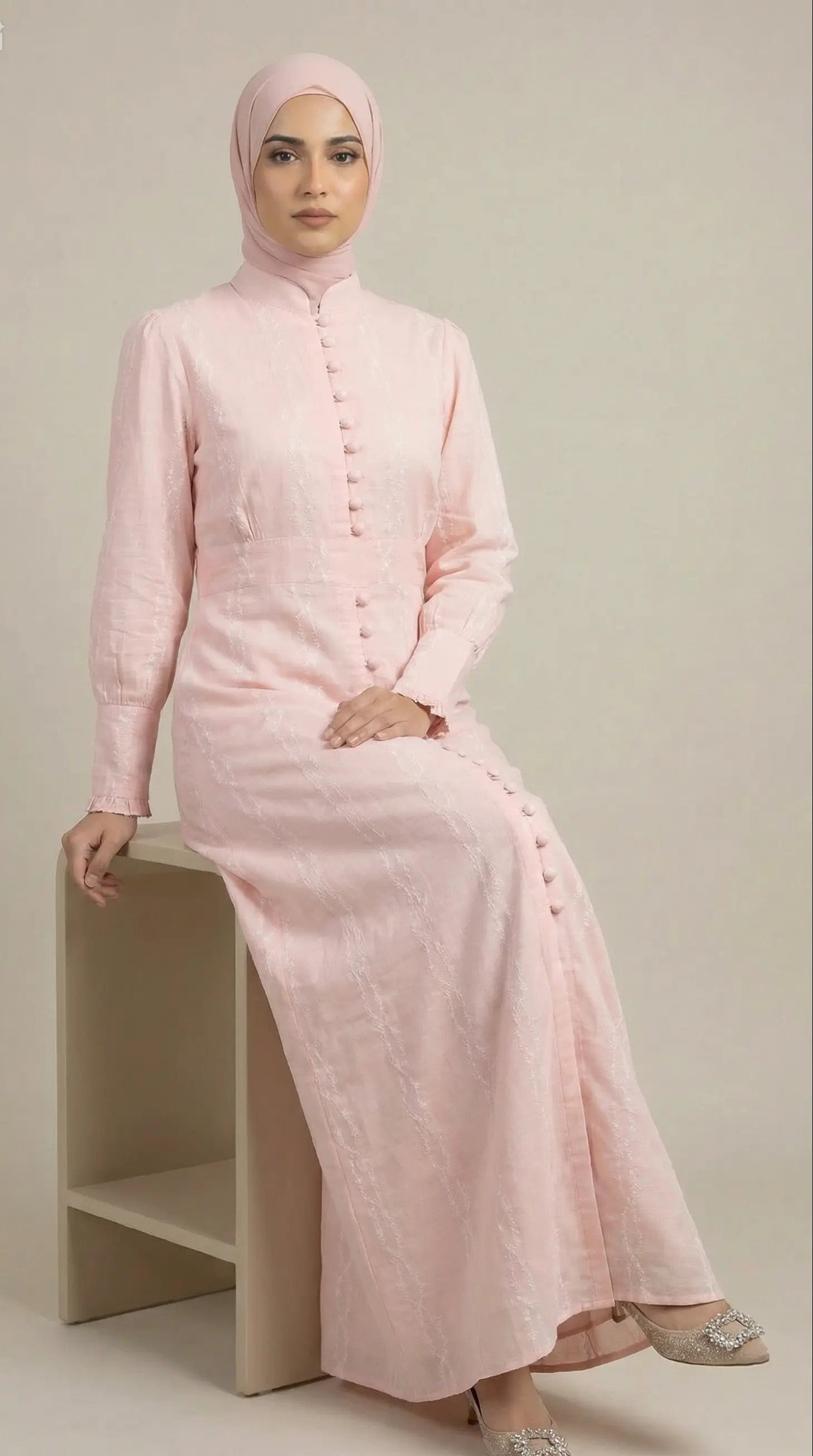 Seated view of Peach Aura blush modest maxi dress with long sleeves